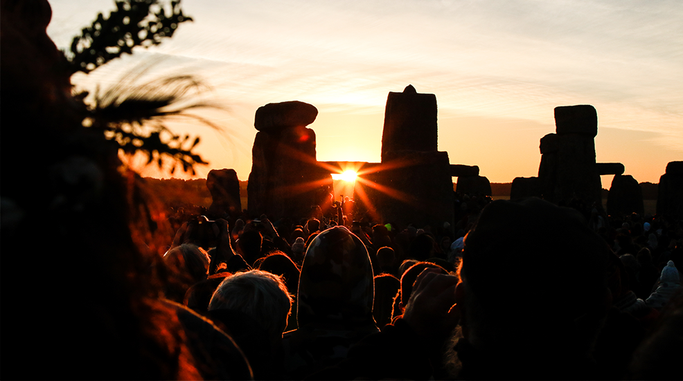 Crowds celebrating summer solstice and the dawn of the longest day of the year at Stonehenge